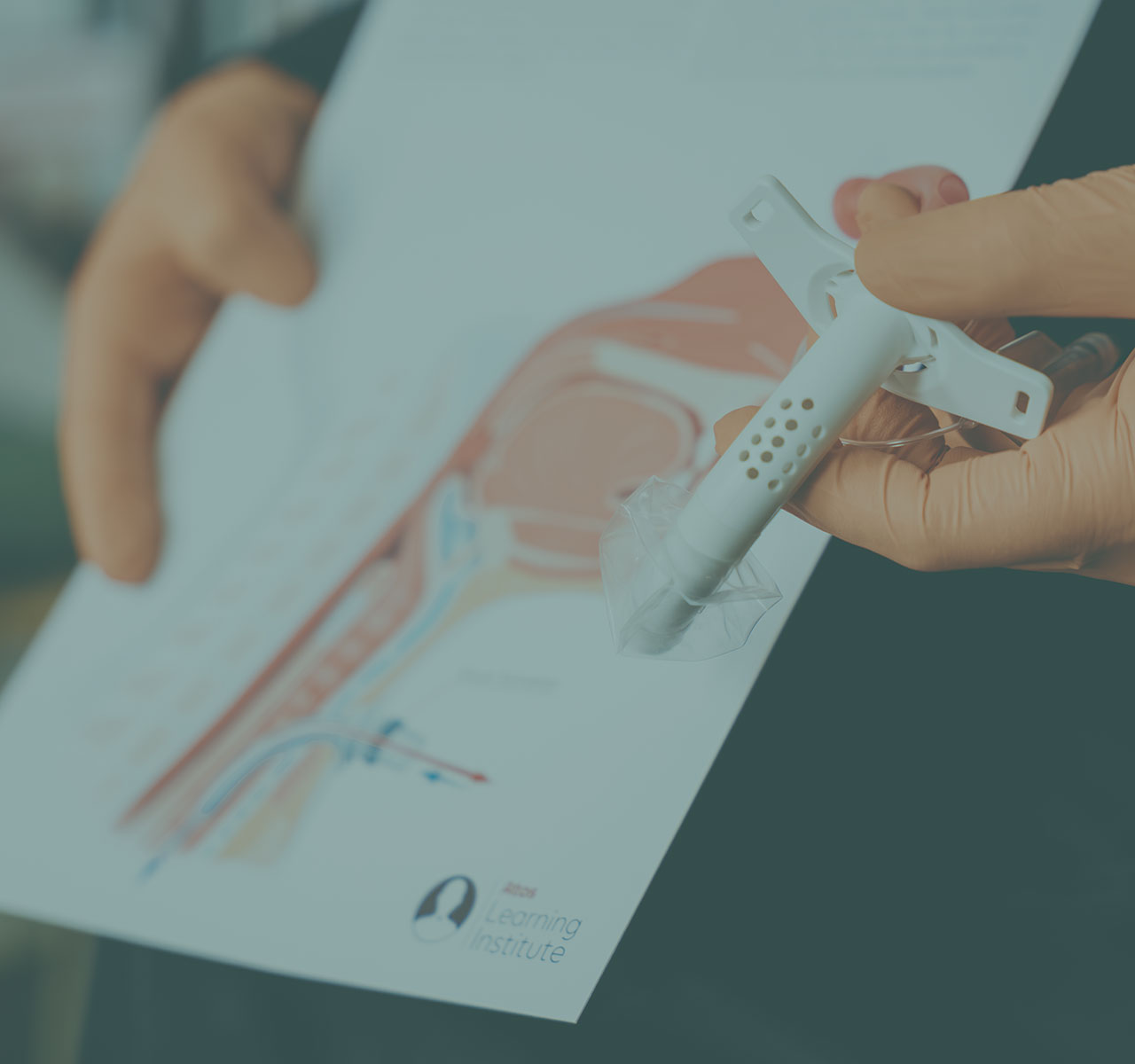 Eine Hand hält eine Trachealkanüle vor einer anatomischen Darstellung der Atemwege zur Erklärung der Versorgung